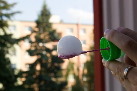Floating soap bubbles filled with smoke on the bubble blower in  hand man Stock Photos