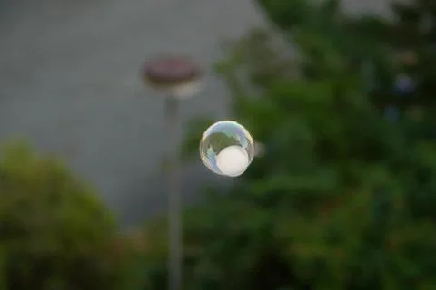 Floating soap bubbles filled with smoke in the center of the town. Stock Photos