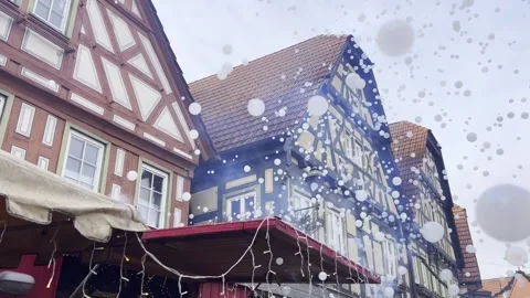 Floating soap bubbles in front of traditional half-timbered buildings in Stock Footage 334579936