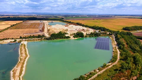 Floating solar array and sand quarry lake landscape. Photovoltaic panels sit on Vídeos de archivo 346007382
