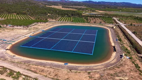 Floating solar panel array installed on agricultural irrigation reservoir Stock Footage 333438522