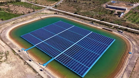 Floating solar panel array installed on a reservoir surrounded by arid land Vídeo Stock 345426392