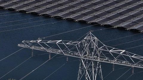 Floating solar panel farm and electricity pylon generating green energy Stockbeeldmateriaal 333390504