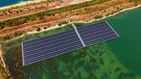 Floating solar panels on green quarry pond water. Photovoltaic module array sits Vídeo Stock 346007413