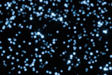 Floating specks of light on black background, 3d rendering. Stock Illustration