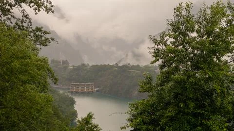 Floating Structure on Misty Mountain Lake Surrounded by Lush Greenery and S.. Stock Photos