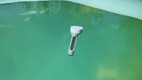 Floating thermometer bobbing in swimming pool Stock Footage 342430460