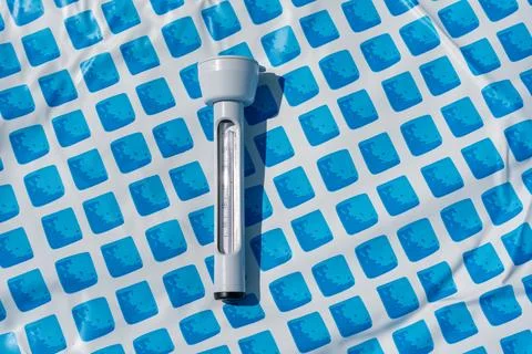 Floating thermometer for the pool on the blue floor pattern. Stockfoto's