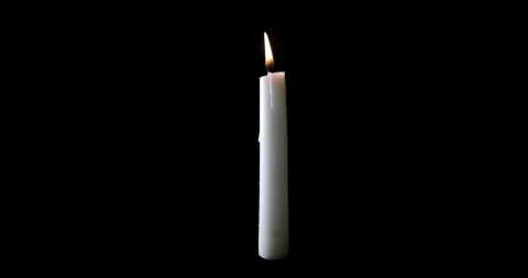 Floating white candle yellow flame on black background dark backdrop Stock Footage 259226006
