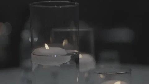 Floating white candles glowing inside clear glass cylinders for decor Stock-Footage 335270885
