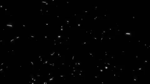 Floating white glowing dust particles moving across dark background with 스톡 동영상 346038615