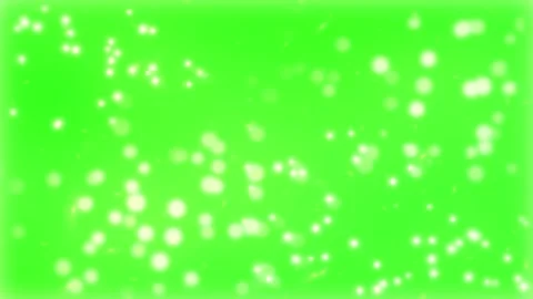 Floating white glowing particles drifting across vibrant green screen Stock Footage 343840291