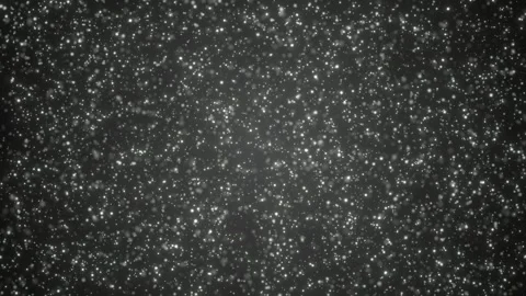 Floating white particles drift in dark space, creating an abstract dust Stock Footage 324956833
