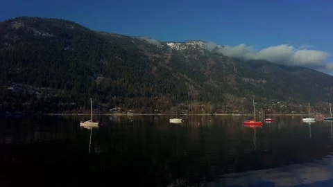 Floating yachts on the foreground of a mountain Vídeos de archivo 222025652