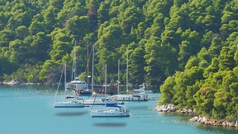 Floating yachts hovering on shallow turquoise water of idyllic lagoon of island Stock Footage 111686074