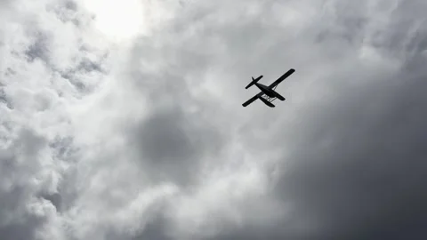 Floatplane drops low over a wide tidal estuary under heavy grey overcast 動画素材 336219913