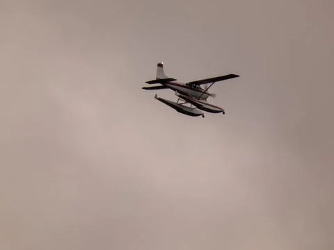 A floatplane flying across a cloudy sky Stock Photos