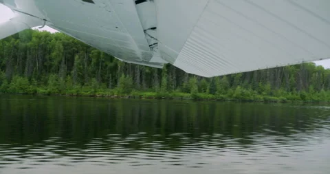 Floatplane taking off from the lake in Alaska. View from the aircraft Stock Footage 317361278