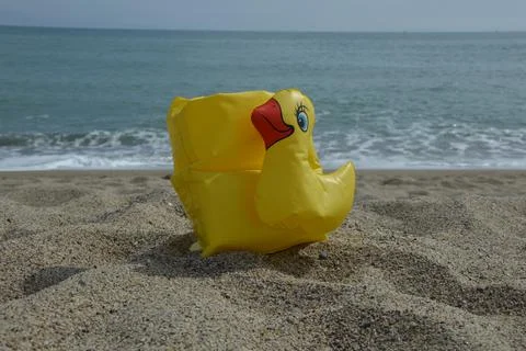 Floaty in a shape of a duck on the beach sand. Stock-Fotos