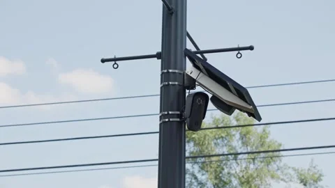 FLOCK camera powered by solar panel on pole monitoring car traffic Stock Footage 343009222