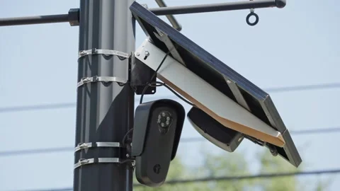 FLOCK camera powered by solar panel on pole monitoring car traffic Stock Footage 343009250