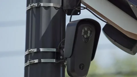 FLOCK camera powered by solar panel on pole monitoring car traffic Stock Footage 343009253