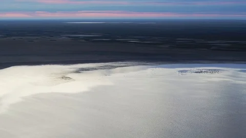 A flock of gray cranes flies over the lake at dawn, shot from a drone Stock Footage 121627238