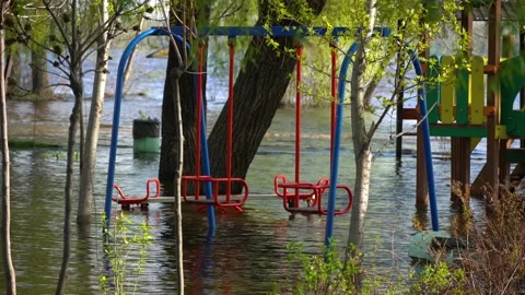Flood on bank river in spring time. Water filled play and sport grounds in city. 스톡 동영상 239371271