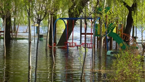 Flood on bank river in spring time. Water filled play and sport grounds in city. 스톡 동영상 239371272