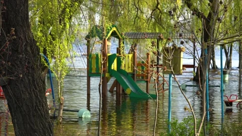 Flood on bank river in spring time. Water filled play and sport grounds in city. 스톡 동영상 239371278