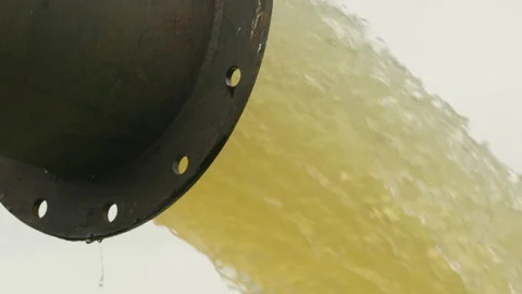 Flood protection drainage system, water flows through pipes into river. Stock Footage 346622219