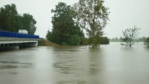 Flood spilling water muddy swollen river start bridge begins field flooded Vídeo Stock 287916853
