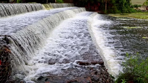 Flood water flowing over a three tier weir in a canal after heavy rain. Stock Footage 297836680