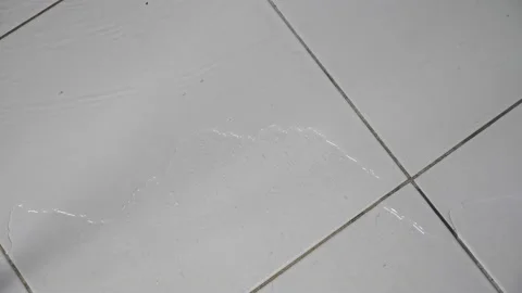 Flood water flows over white ceramic tile floor in bathroom Stock Footage 167330266