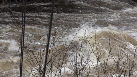 Flood waters rushing over dam during severe flooding after rain storm Stock Footage 106706751