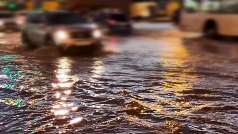 Flooded city road with large puddle. Flooding after heavy rains at city Stockbeeldmateriaal 220445644