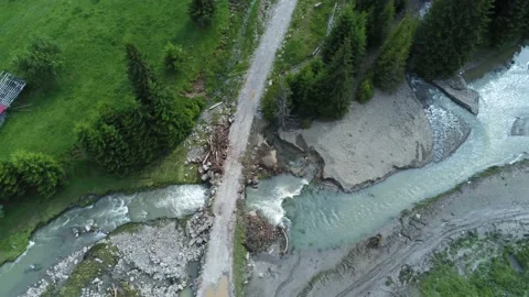 Flooded mountain river flowing under the forest road aerial drone view Stock Footage 156510548