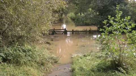 Flooded path in park, gate and fence underwater Stock-Footage 12591836