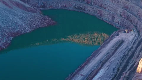 Flooded quarry basin forming deep excavation with turquoise water collecting Stock Footage 326676713