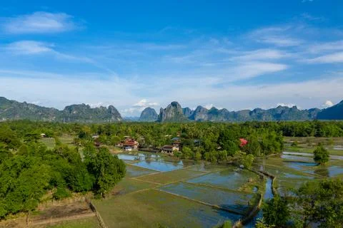 Flooded rice fields and limestone mountains in Laos Stockfoto's
