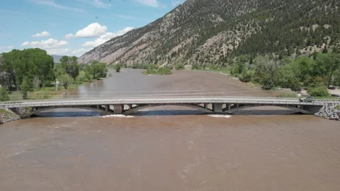 Flooded river almost over bridge Stock Footage 166329397