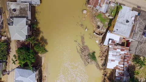 Flooded river and damaged homes, Dominican Republic. Aerial top-down forward 動画素材 332802389