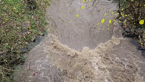 Flooded river and powerful waterfall after extreme rain in slow motion Video stock 320551736