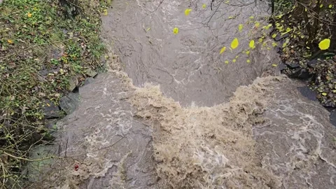 Flooded river and powerful waterfall after extreme rain in slow motion Video stock 321383794