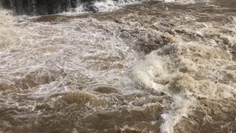 Flooded river flowing foaming through stone boulders rock Raging stream of .. Stock Footage 284431032