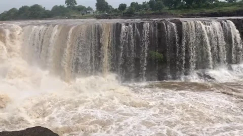 Flooded river flowing through stone boulders rock Raging stream of strong b.. Stock Footage 284430684