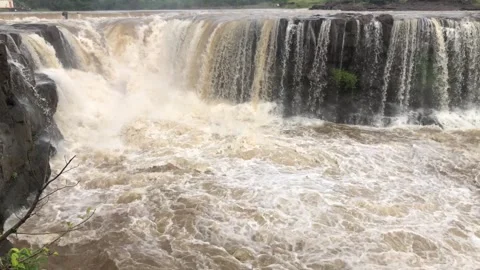 Flooded river flowing through stone boulders rock Raging stream of strong b.. Stock Footage 284431238