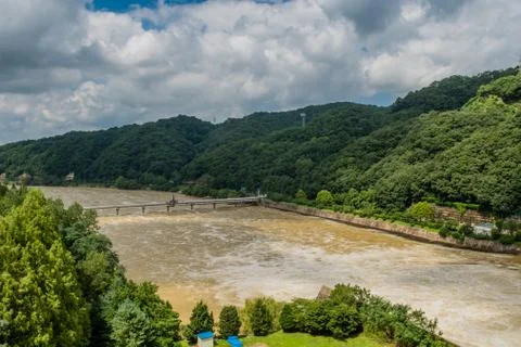Flooded river under cloudy sky after torrential rains. Stock Photos