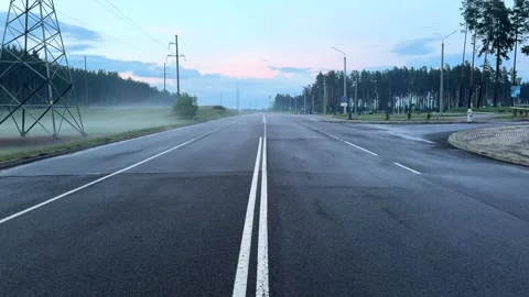 A flooded road after rain with power lines and a foggy pine forest  Vídeo Stock 336103995