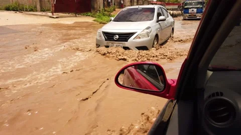 Flooded road with vehicles passing. Video stock 136375669